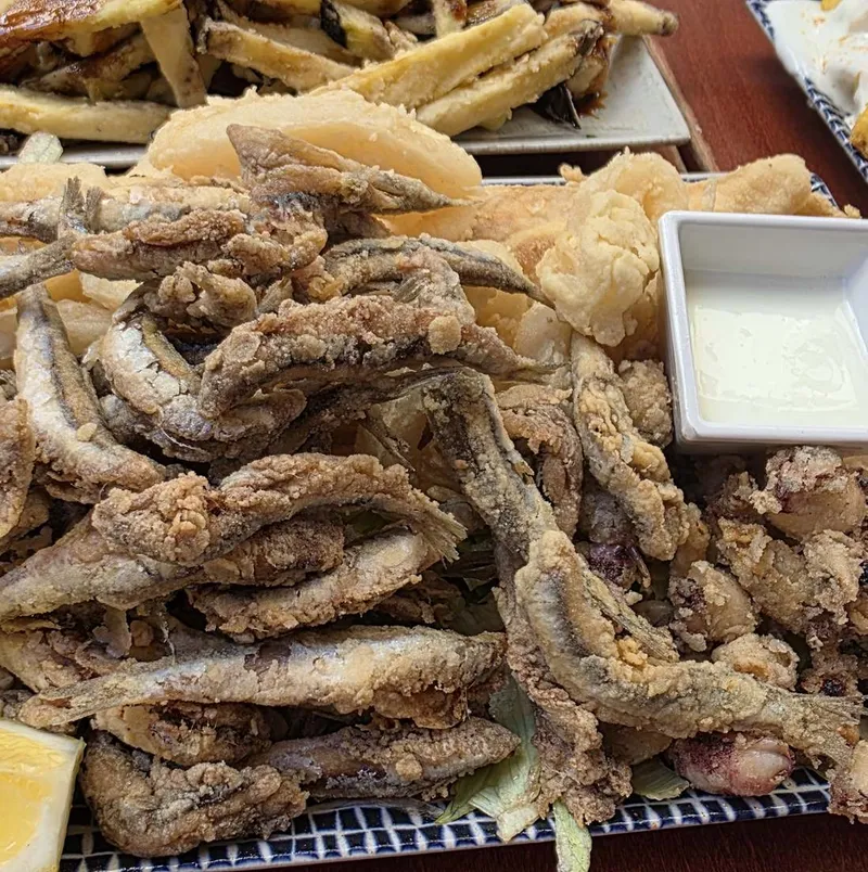 A platter of fried anchovies and squid with a dish of aioli