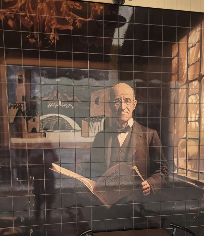 Tile mural in the passage: an elderly composer in round glasses holding an open score by a window